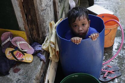 Un niño se baña dentro de un recipiente de plástico en Cavite (Filipinas), durante una cuarentena comunitaria para evitar la propagación del coronavirus.