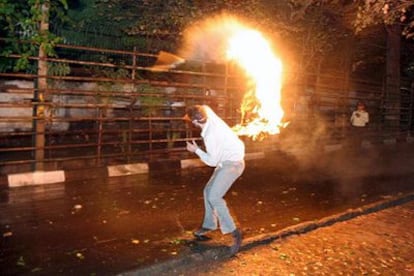 Un estudiante iraní lanza una botella incendiaria contra la Embajada de Dinamarca, anoche en Teherán.
