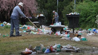 Operarios de limpieza recogen los restos del macrobotellón de "San Cemento".