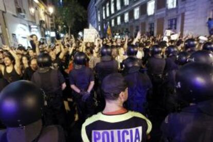 Cientos de indignados del movimiento 15M se manifiestan en la calle Carretas de Madrid, junto a la Puerta del Sol, ante una barrera policial.