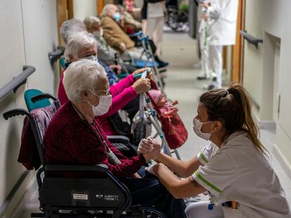Una enfermera atiende a personas mayores antes de vacunarse.