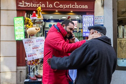 Varias personas en el exterior de la administración de lotería número 12 de Toledo, La Caprichosa, que ha vendido parte del primer y del tercer premio del sorteo extraordinario del Niño de este sábado.