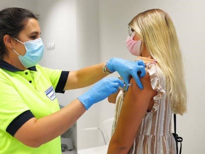 Una sanitaria vacuna a una mujer en un centro de salud.