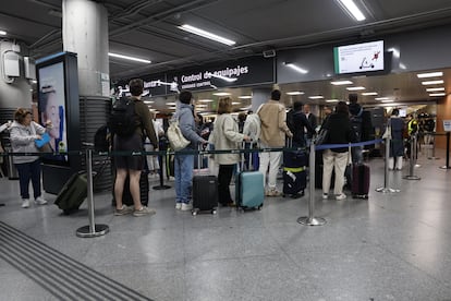 Varias personas esperan para pasar el control de equipajes en la estación de Atocha en Madrid este lunes.