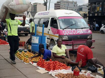 Varias personas venden fruta y verdura ayer en una calle de Harare. 