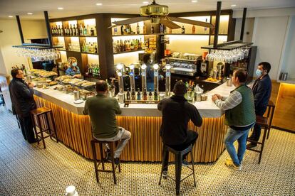 Los clientes de un bar del centro de Vitoria toman café en la barra por primera vez desde la declaración del estado de alarma, al entrar en vigor este lunes en Euskadi la fase 3 de la desescalada.