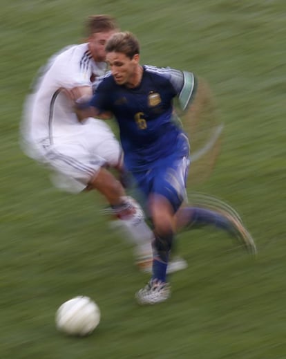 Christoph Kramer de Alemania (L) lucha por el balón con Lucas Biglia.