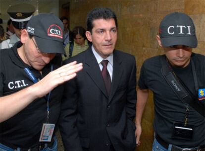 El ex director de fiscalías de Medellín, Guillermo León Valencia, custodiado por la policía colombiana.