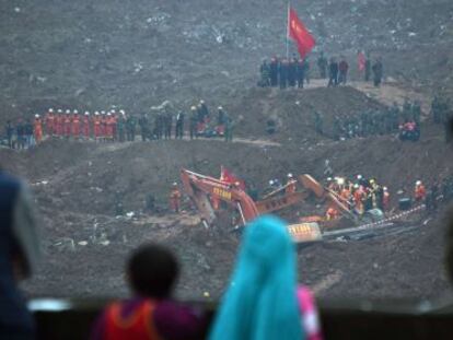 Un grupo de personas observa este lunes las labores de rescate tras el derrumbe de 33 edificios en Shenzhen, China.