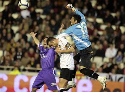 Villar despeja un balón de puños saltando por encima de Marchena.