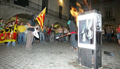 Dos encaputxats cremen una foto dels Reis davant de l'Ajuntament de Girona el setembre del 2007.