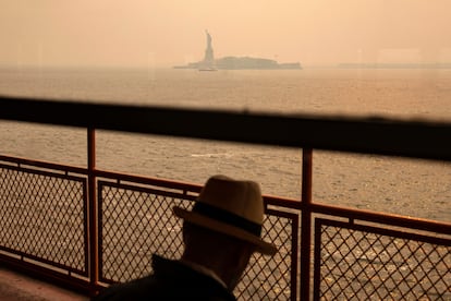 El humo que se desplazó hacia el sur desde los incendios forestales canadienses crea una neblina sobre el puerto de Nueva York, mientras el ferry de Staten Island pasa por la Estatua de la Libertad, el 7 de junio. 