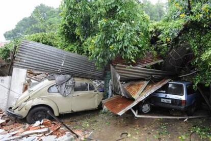Imagen de una casa derrumbada sobre dos vehículos en Ilha do Governador, una zona del norte de Río de Janeiro, a causa de las lluvias. En este siniestro ha fallecido una mujer y han resultado heridas dos niñas.