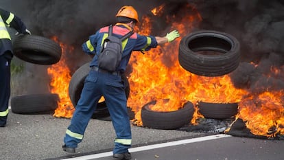 Un trabajador de Alcoa San Cibrao quema neumáticos durante una manifestación.