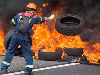 Un trabajador de Alcoa San Cibrao quema neumáticos durante una manifestación.