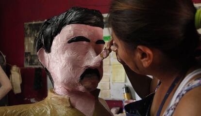 An artist puts the finishing touches on an 'El Chapo' piñata in Tamaulipas.