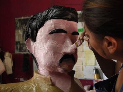 An artist puts the finishing touches on an 'El Chapo' piñata in Tamaulipas.
