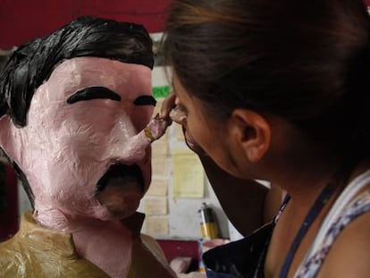 An artist puts the finishing touches on an 'El Chapo' piñata in Tamaulipas.