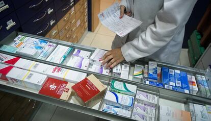 Un farmacéutico coge un medicamento