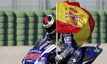 Lorenzo porta una bandera de España tras ganar la carrera y el mundial de Moto GP en el circuito "Ricardo Tormo" de Valencia.