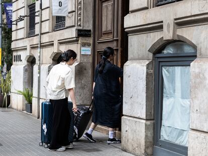 Dos turistas entran en un portal del distrito de L'Eixample en Barcelona, el mes pasado.