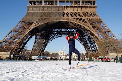 Un hombre, con los esquíes calzados, se desliza en la base de la Torre Eiffel.