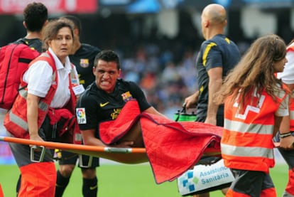 El delantero chileno Alexis Sánchez se retira lesionado en camilla durante el partido frente a la Real Sociedad.