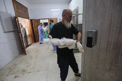Personal sanitario traslada el cuerpo de un bebé a la morgue de un hospital de Jan Yunis. 