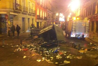 Restos de un contenedor volcado en la Plaza de Tirso de Molina.