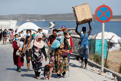 Refugiados del campo incendiado en Moria caminan hacia un campamento temporal el pasado lunes en Lesbos, Grecia