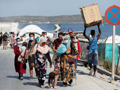 Refugiados del campo incendiado en Moria caminan hacia un campamento temporal el pasado lunes en Lesbos, Grecia