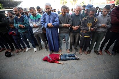 Varios hombres rezan ante al cadáver de un niño palestino, en Gaza este martes.