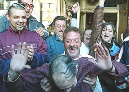 Algunos clientes del bar Asturias, en Valencia, celebran que el propietario del establecimiento, que aparece inclinado, repartió parte del<i> </i><b>'gordo'.</b>