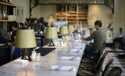 Un hombre observa la pantalla de su ordenador en una cafeter&iacute;a.