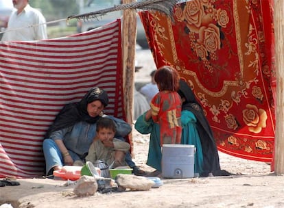 Una familia paquistaní en un campamento de refugiados custodiado por la policía de Peshawar.