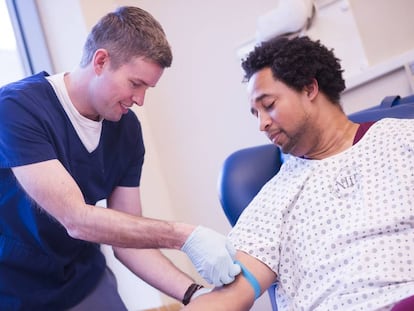 Un sanitario toma una muestra de sangre de un paciente.