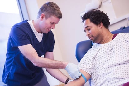 Un sanitario toma una muestra de sangre de un paciente.