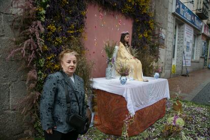 Una mujer posa para ser retratada al lado de uno de los seis altares donde se exhiben las Mayas el día 2 de mayo en Colmenar Viejo. 