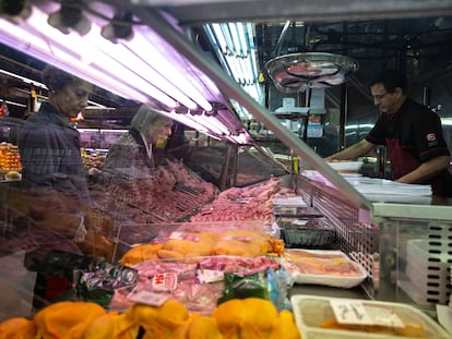 Dos mujeres compran en una carnicería en un mercado de Madrid.