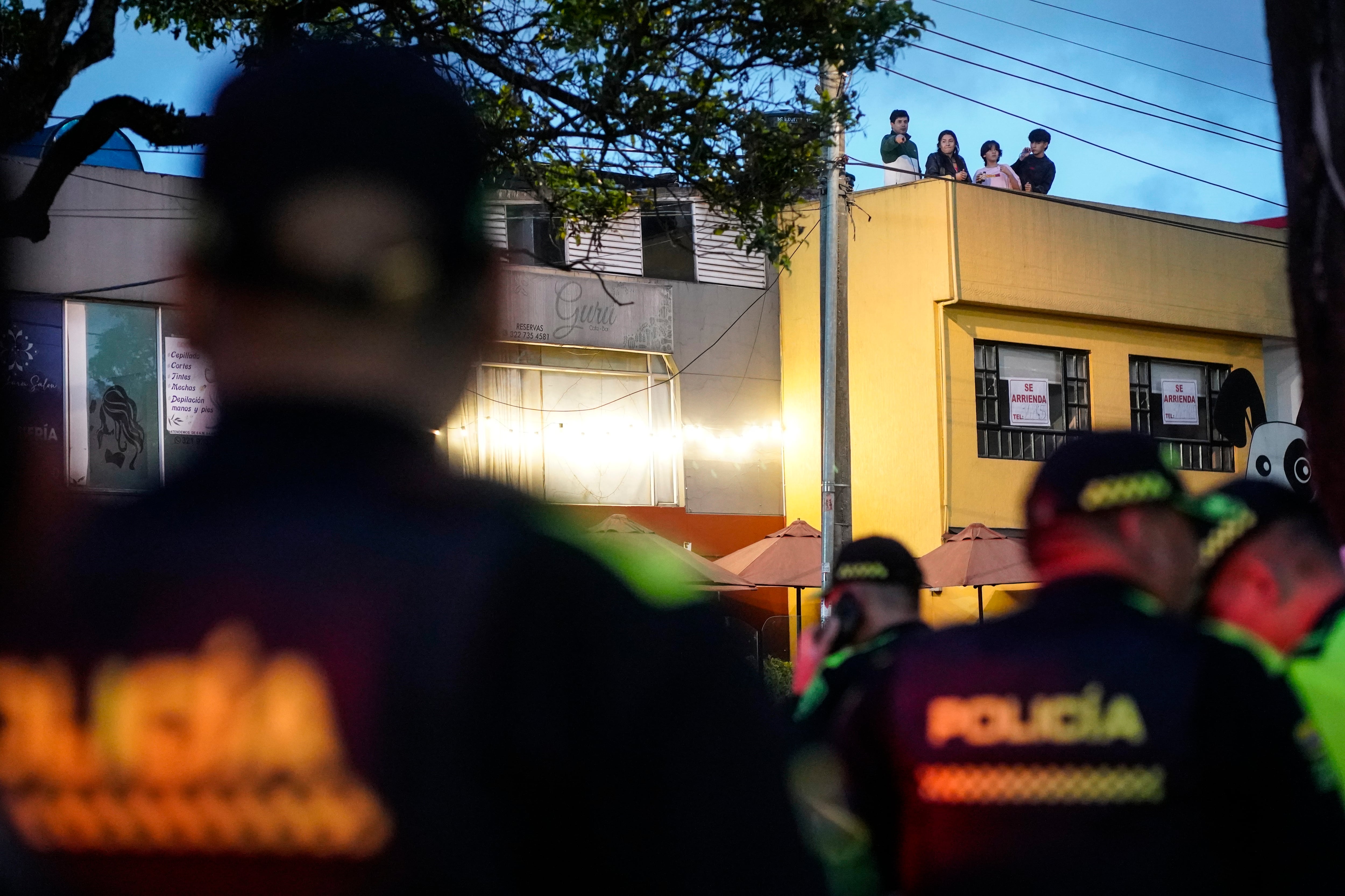 Vecinos del sector del barrio de Modelia miran desde el operativo de la Policia Nacional tras el atentado.