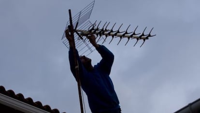 Una operario ajusta la antena en un tejado de Colmenar Viejo (Madrid).