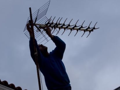 Una operario ajusta la antena en un tejado de Colmenar Viejo (Madrid).