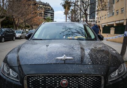 Un Jaguar de lujo que fue extraído del edificio calcinado (en el fondo de la imagen), tras permanecer en el aparcamiento desde el momento del incendio. 