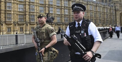 Un soldado británico y un policía patrullan por los alrededores del Parlamento de Londres.