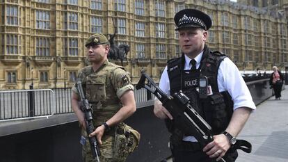 Un soldado británico y un policía patrullan por los alrededores del Parlamento de Londres.