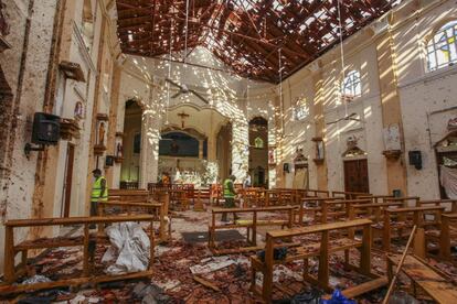 Policías, en el interior de la iglesia de San Sebastián, en Negombo, tras el atentado terrorista.