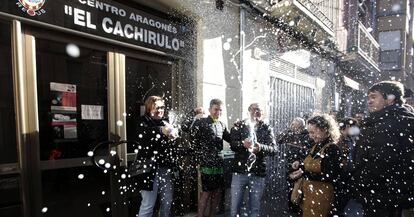 Un grupo de personas celebra haber sido agraciados con el número 26590 el Gordo de Navidad, en el centro aragonés El Chachirulo.