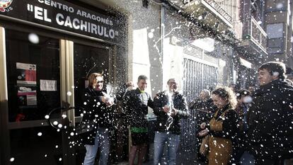 Un grupo de personas celebra haber sido agraciados con el número 26590 el Gordo de Navidad, en el centro aragonés El Chachirulo.