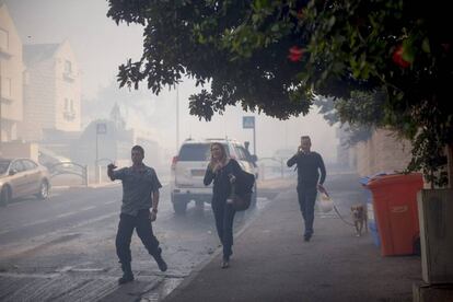 Residentes huyen del humo provocado por un incendio que comenzó a propagarse cerca de un barrio en la ciudad de Haifa, al norte de Israel, el 24 de noviembre de 2016.