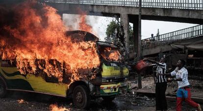 Simpatizantes de la coalición Súper Alianza Nacional (NASA) arrojan agua a un autobús en llamas en Nairobi.
